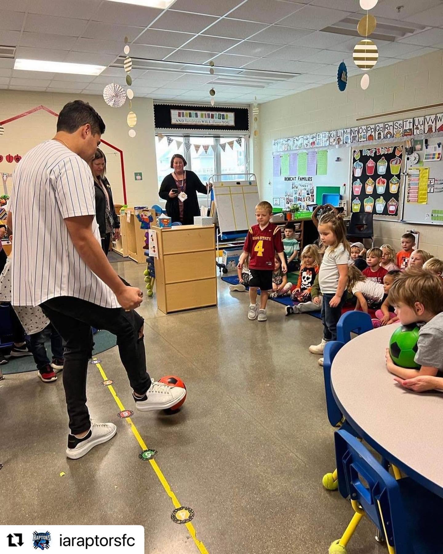 Carlos demonstrating soccer skills to elementary school students in an Iowa classroom